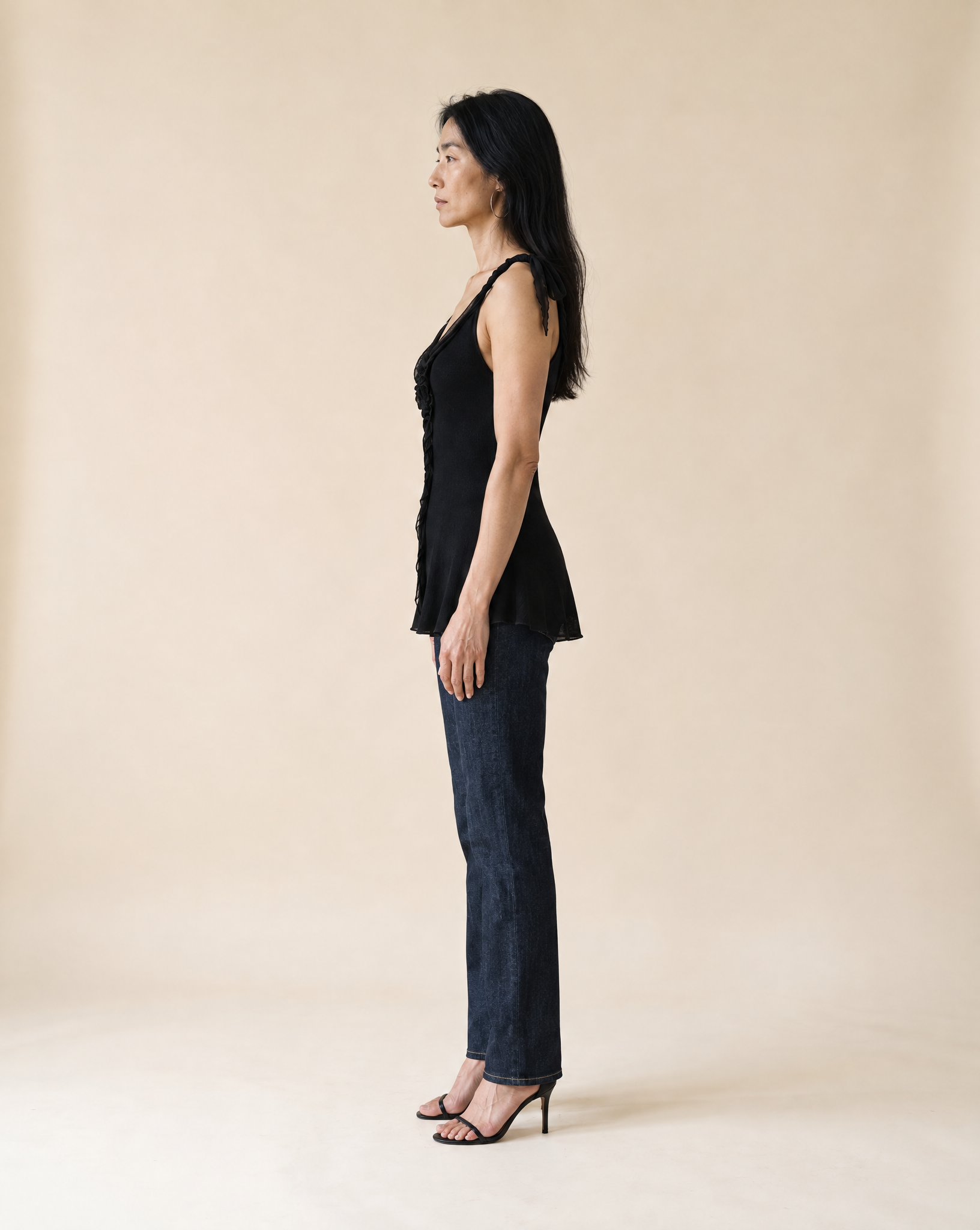 Generated_with_Kive.ai_-_Mina_Vintage_Black_Silk_Knit_Tank_Create_a_full-length_side-profile_fashion_photograph_of_Mina_wearing_the_same_black_silk_knit_tank__dark_straight-leg_jeans.png